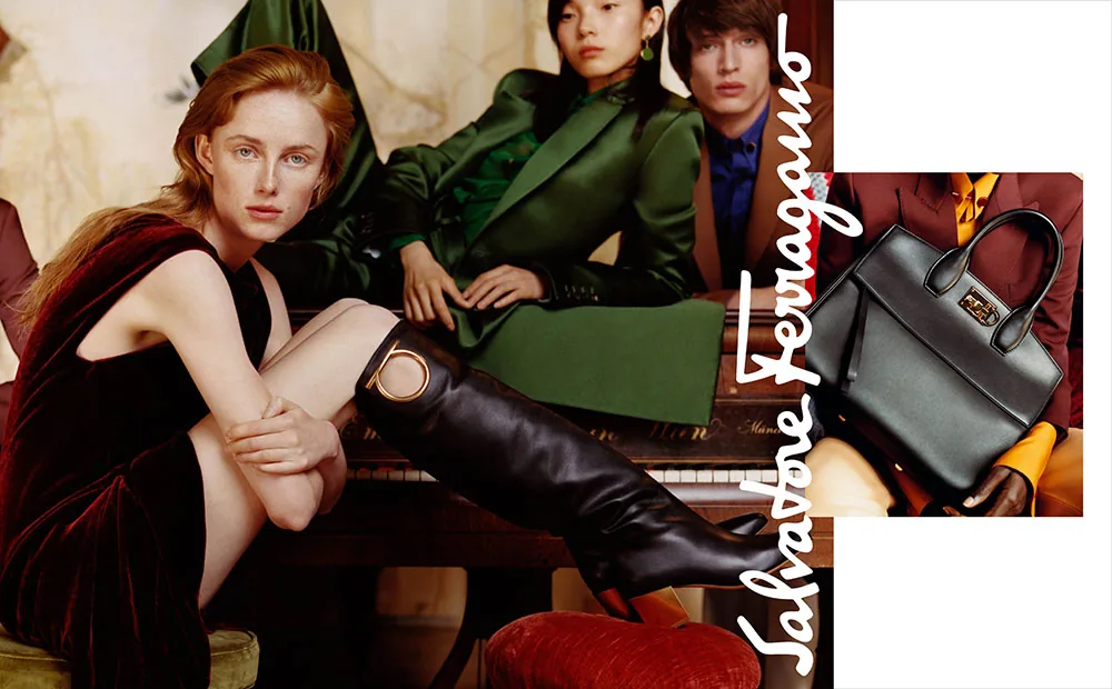 Salvatore Ferragamo FW18 campaign still: a red-haired model in black and tall boots with guests in green, by Harley Weir