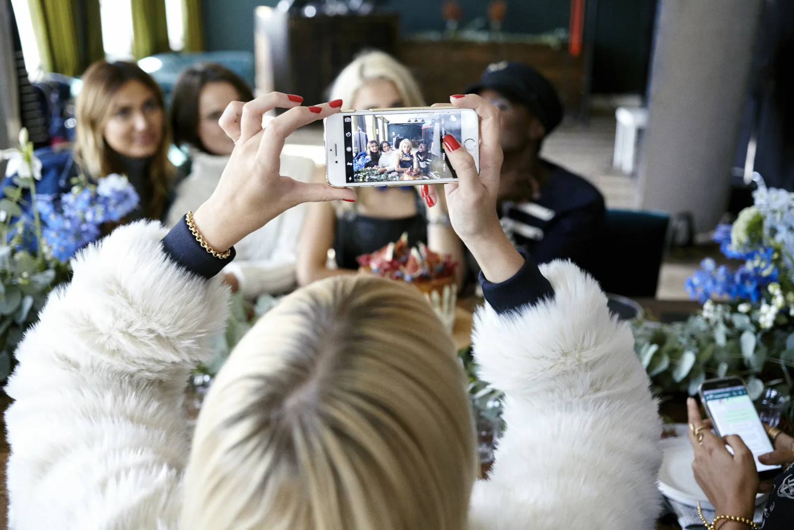 Guests photograph the table on their phones at the Tommy x Gigi dinner in Berlin