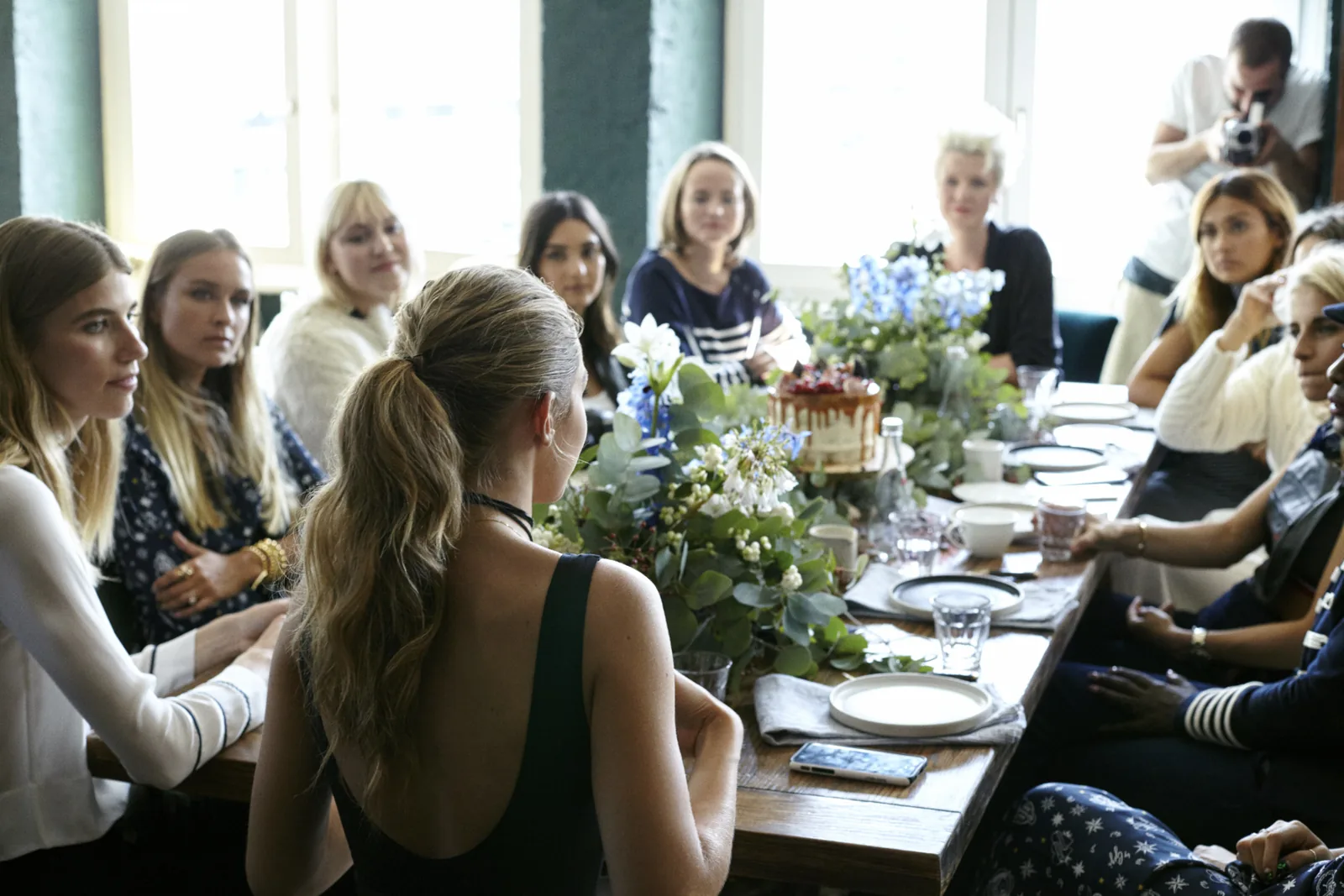 Guests seated along a long flower-decked table at the Tommy x Gigi dinner in Berlin