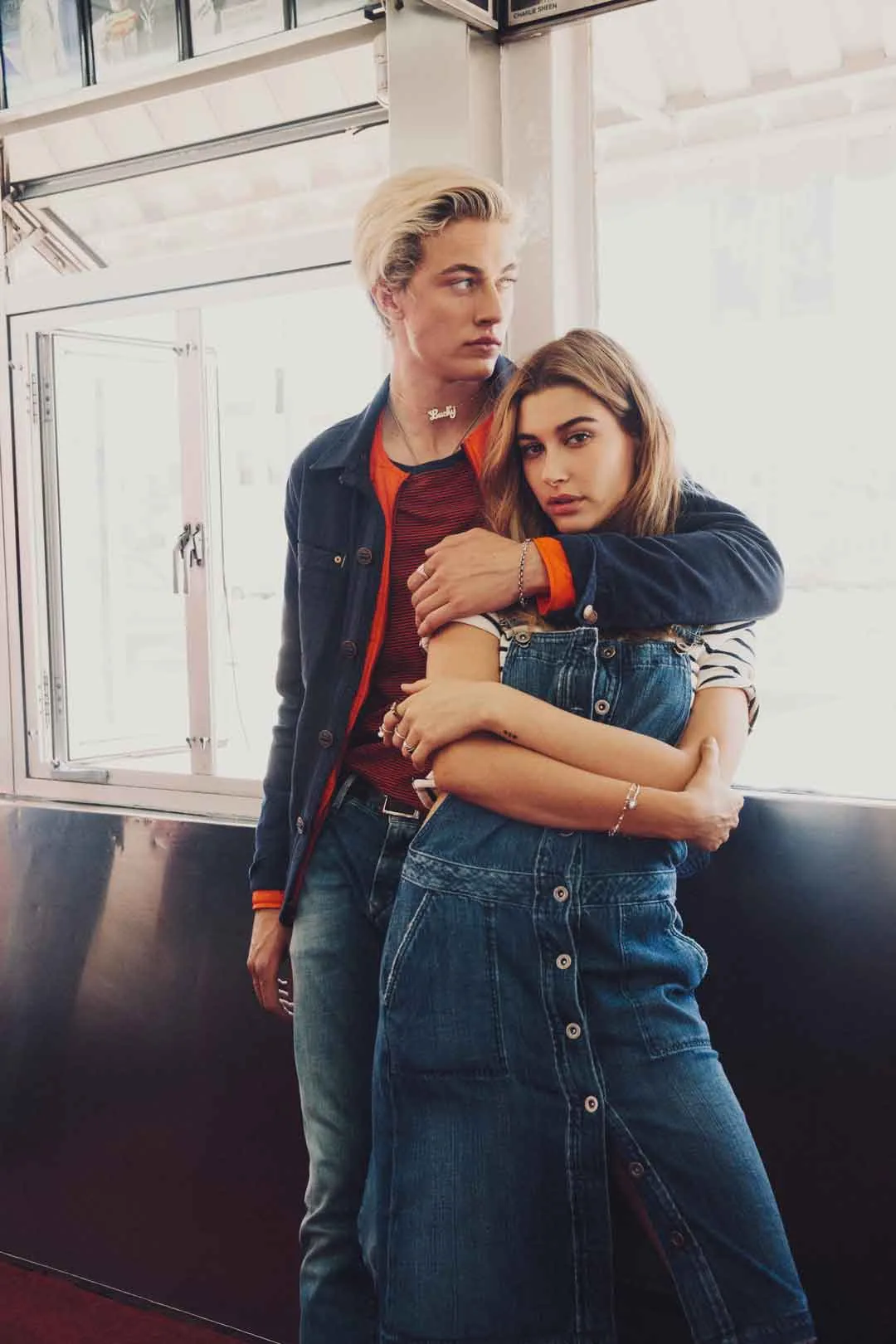 Lucky Blue Smith hugs Hailey Baldwin from behind in a diner window, shot by Bryant Eslava