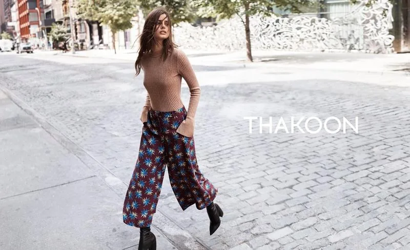 Thakoon Fall 16 campaign still: model in a tan top and floral wide-leg trousers on a cobbled street