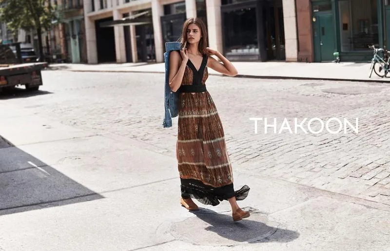 Thakoon Fall 16 campaign still: model in a tiered brown maxi skirt and denim jacket crossing a street