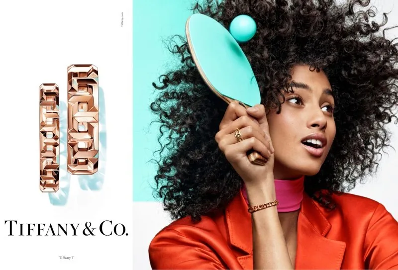 Tiffany T 2019 ad: rose-gold T link bracelets beside a curly-haired model with a Tiffany blue ping-pong paddle