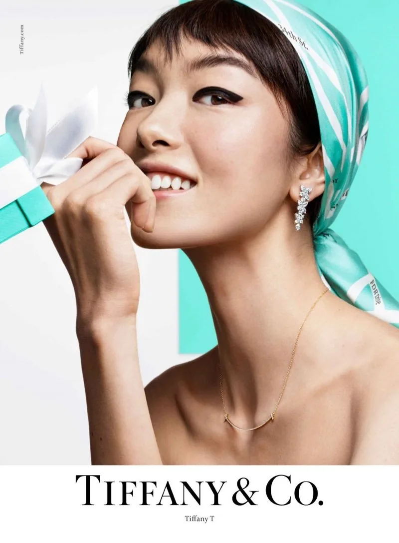 Tiffany T 2019 ad: a smiling model in a Tiffany blue headscarf holding the ribbon of a blue box