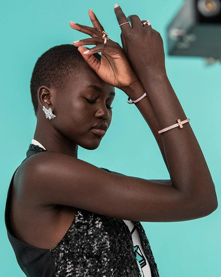 Tiffany T1 campaign still: a model with cropped hair raises her arms to show T1 bracelets and rings