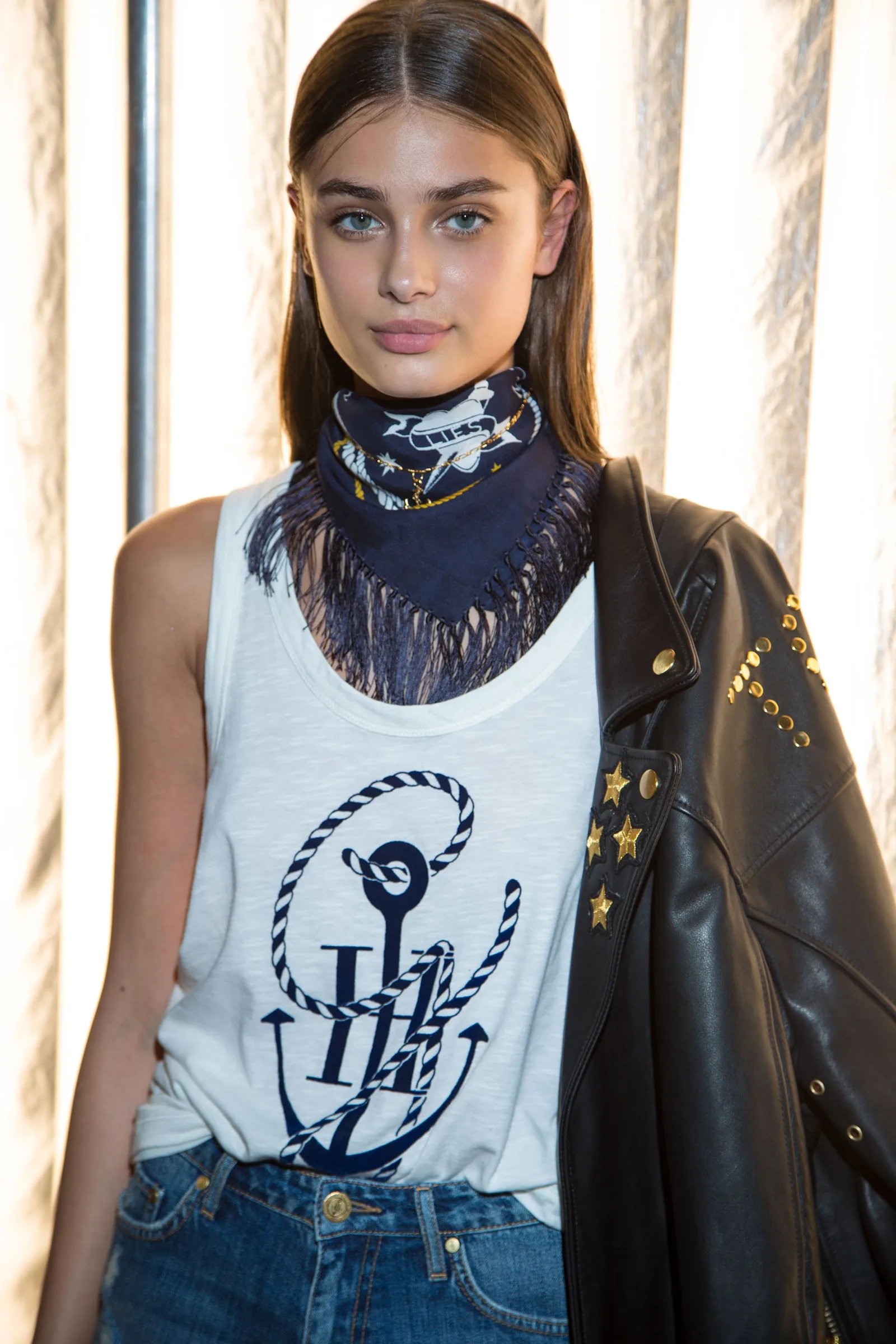 TommyNow backstage: a model in an anchor-print tank, fringed bandana and studded leather jacket