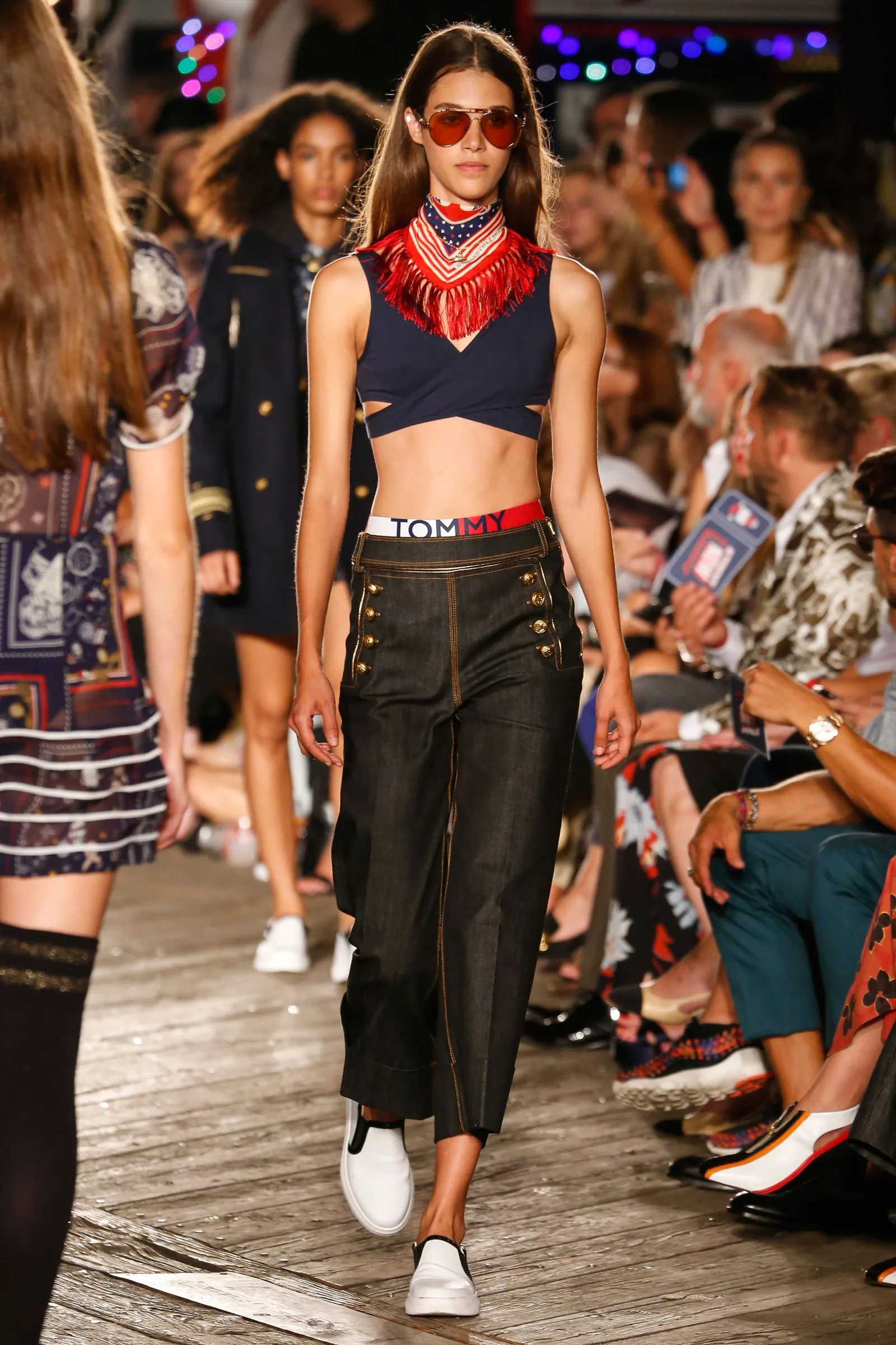 TommyNow runway look: a model in a red bandana, navy crop top and sailor trousers